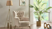 A beige tufted wingback armchair in a bright, modern living room setting.
